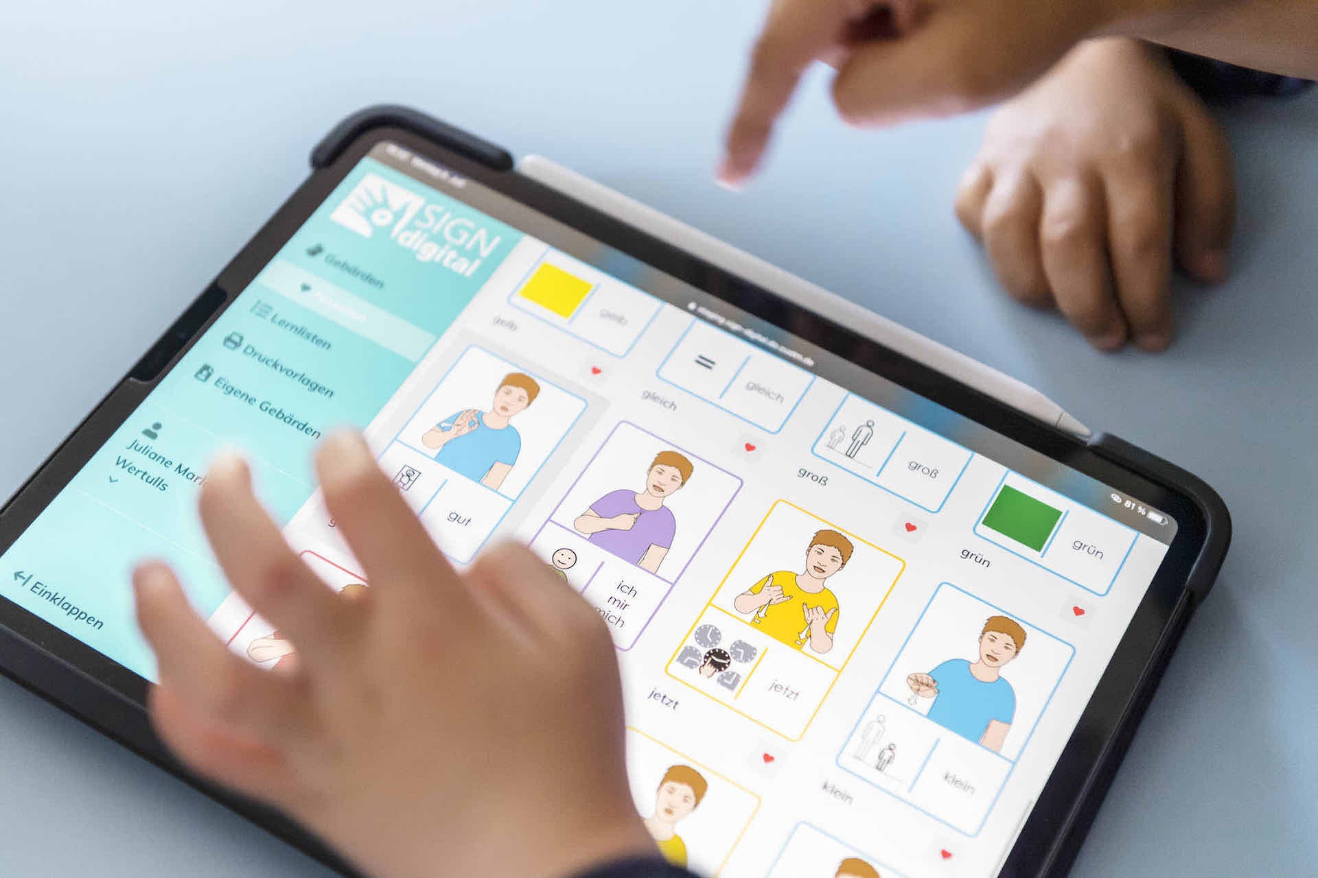 Kinderhände bedienen SIGNdigital auf einem iPad® Tablet.