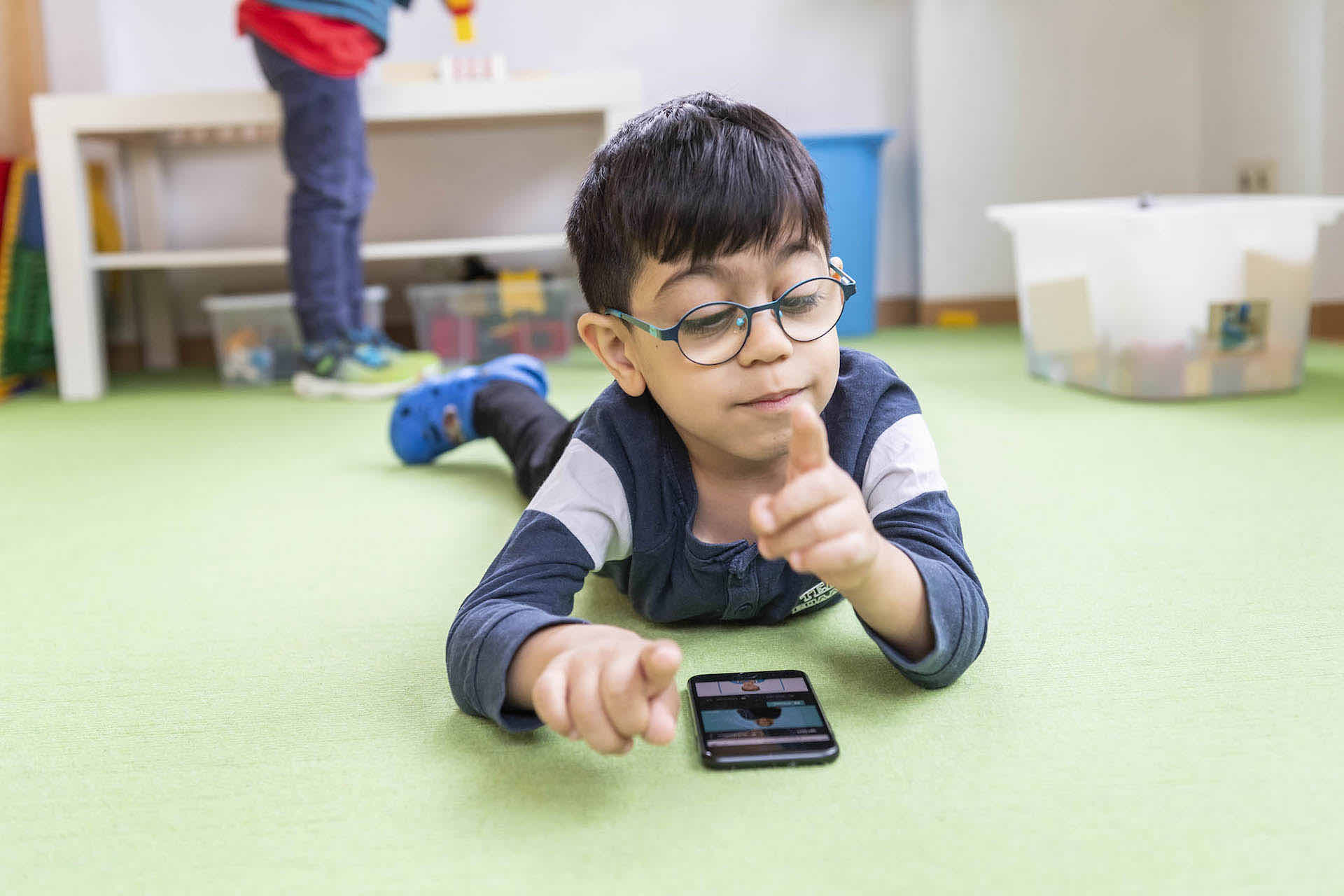 Junge spielt ein SIGNdigital Gebärdenvideo auf dem Smartphone ab.